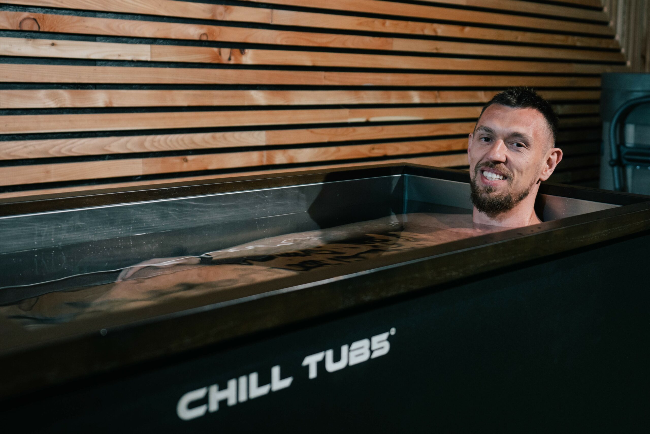 Chill Tubs managing director Rob Carlin sat in a Chill Tubs cold plunge ice bath. He is smiling at the camera.