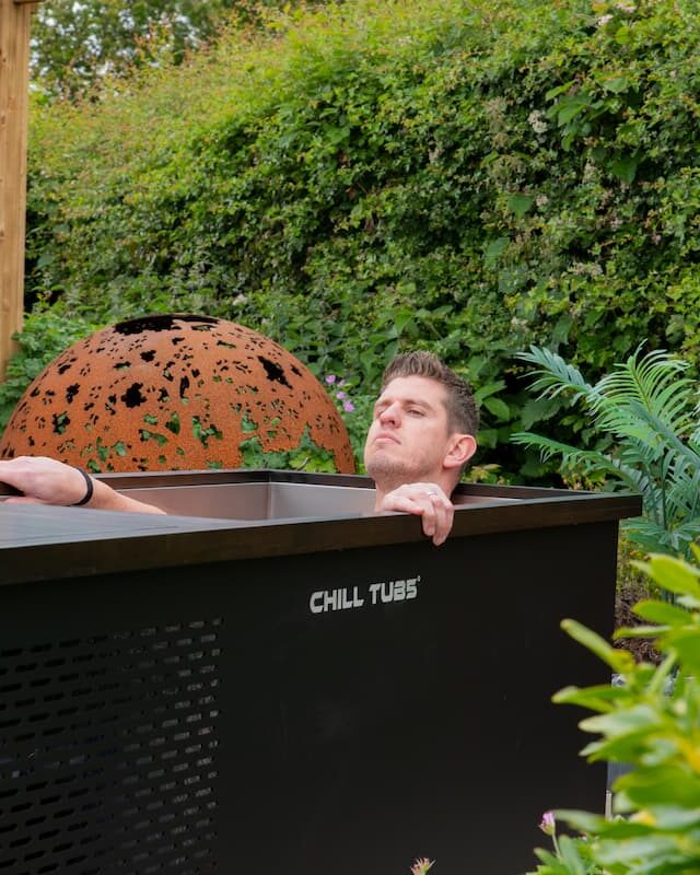 Someone using a Chill Tub Original ice bath in a garden.